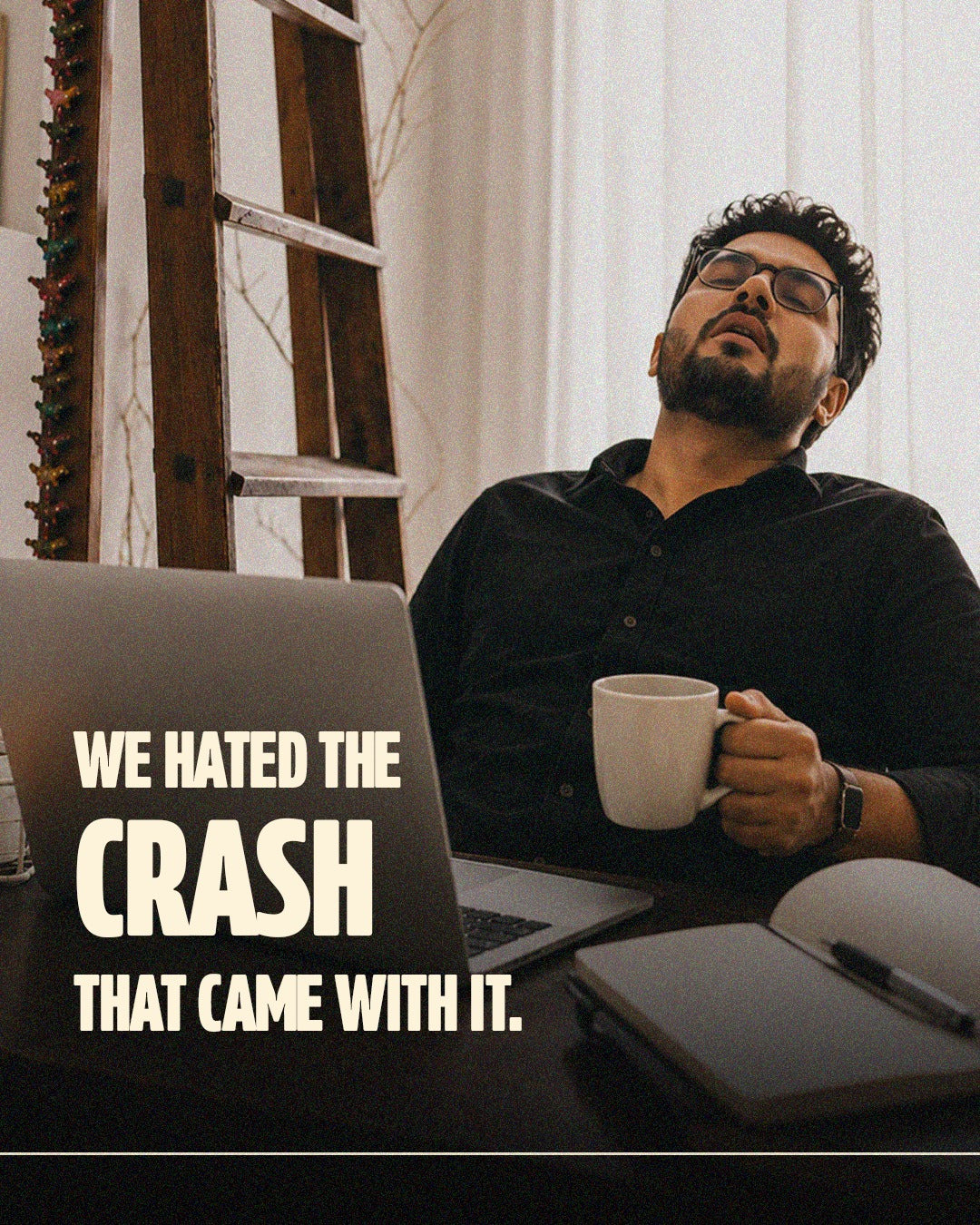 A tired coffee drinker pausing at a laptop with a mug in hand