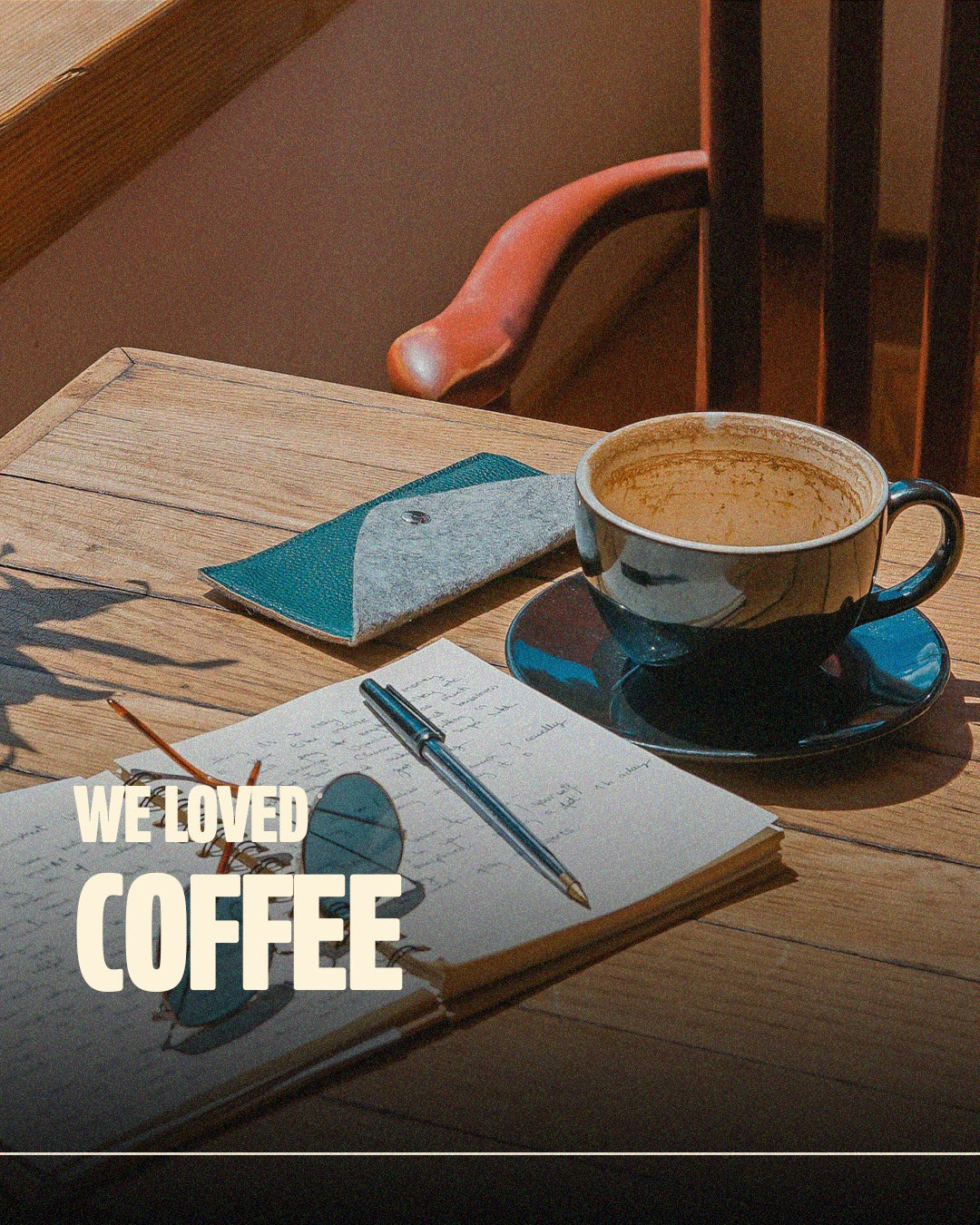 Coffee cup, notebook, and pen on a sunlit table